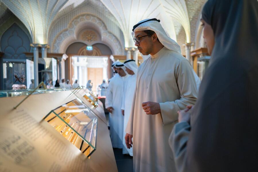 Visitors viewing inclined glass museum display cases inside Qasr Al Watan in Abu Dhabi.