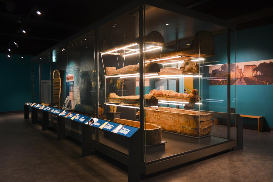 Large free-standing display case with mummies and sarcophagi